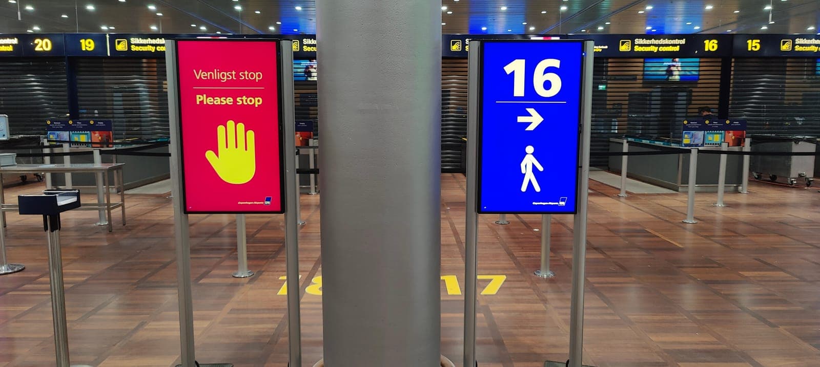 To LED-skærme med stop- og retningsanvisninger ved sikkerhedskontrollen hos Københavns Lufthavne