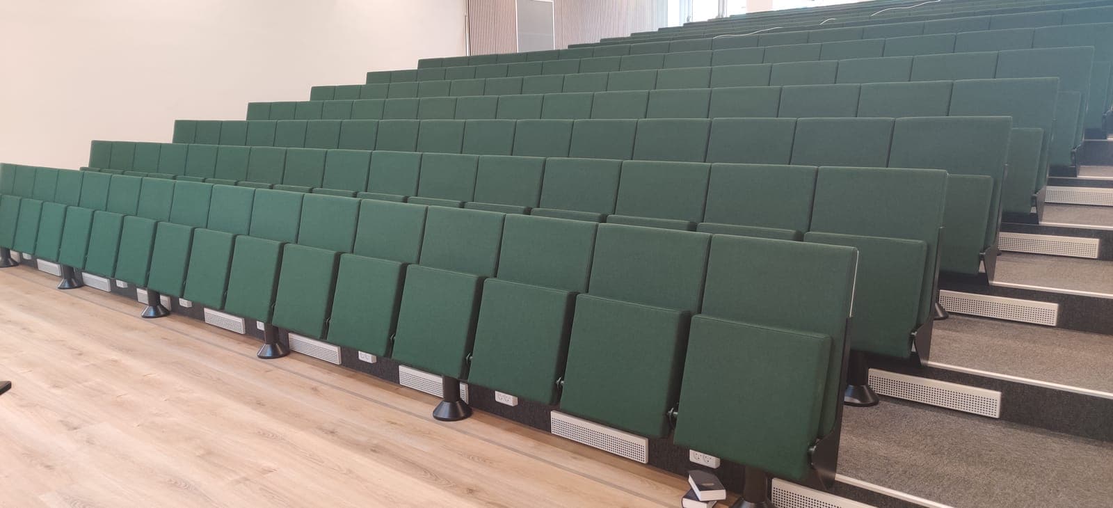 Rækker af grønne tip-up auditoriestole i det nye auditorium på Vesterlund Efterskole