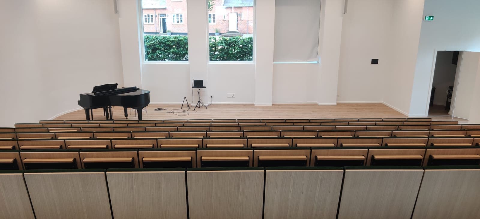 Auditoriet med 224 pladser set bagfra med skriveplader og flygel på Vesterlund Efterskole