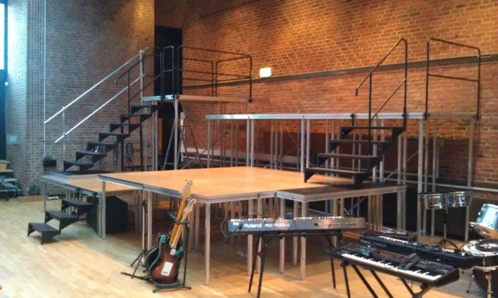 Scenepodier i flere niveauer med trapper og gelændere i musiklokalet på Risskov Gymnasium