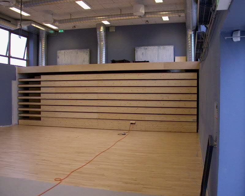 Sammenkørt teleskoptribune, der fylder minimalt langs væggen og frigiver gulvplads i salen på Brøndbyvester Skole