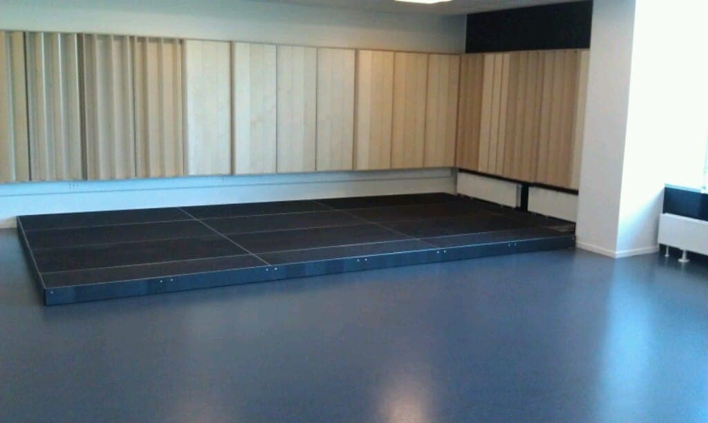 Stor lav scene af sortbejdsede scenepodier samlet til én flade i musiklokalet på Egå Gymnasium