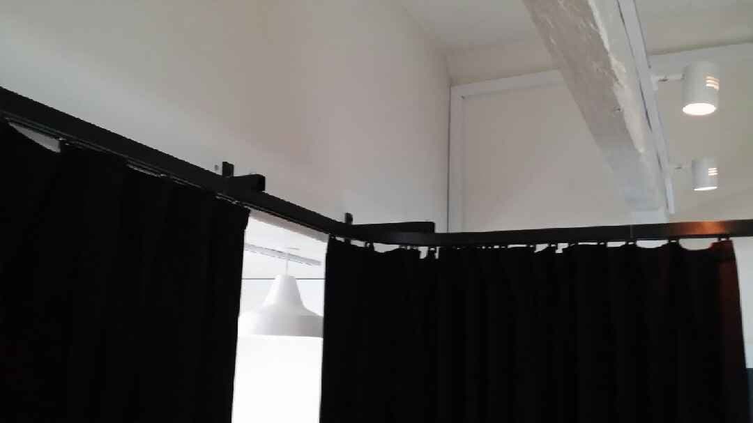 Detalje af sort skinnesystem med hjørne og foldeophængte scenetæpper hos Aarhus Musikskole