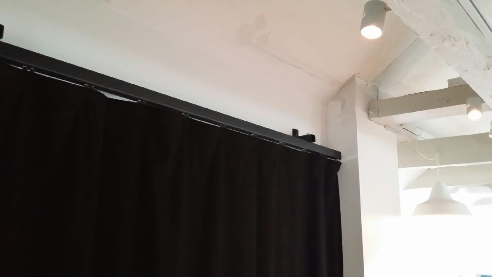 Loftmonteret tæppeskinne ved vægafslutning med sort scenetæppe hos Aarhus Musikskole