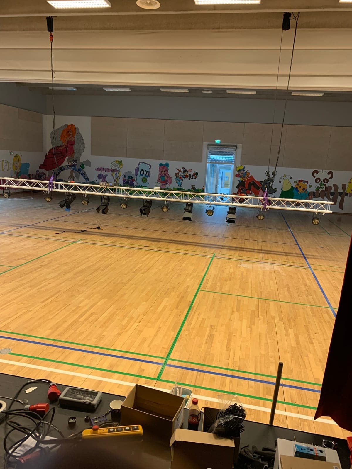 Truss med lysarmaturer sænket ned via elektriske taljer i hallen på Strandgårdskolen i Ishøj